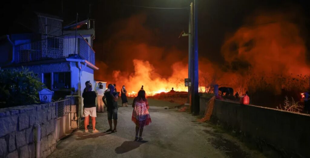 Oamenii urmăresc un incendiu în Canas de Senhorim, Portugalia