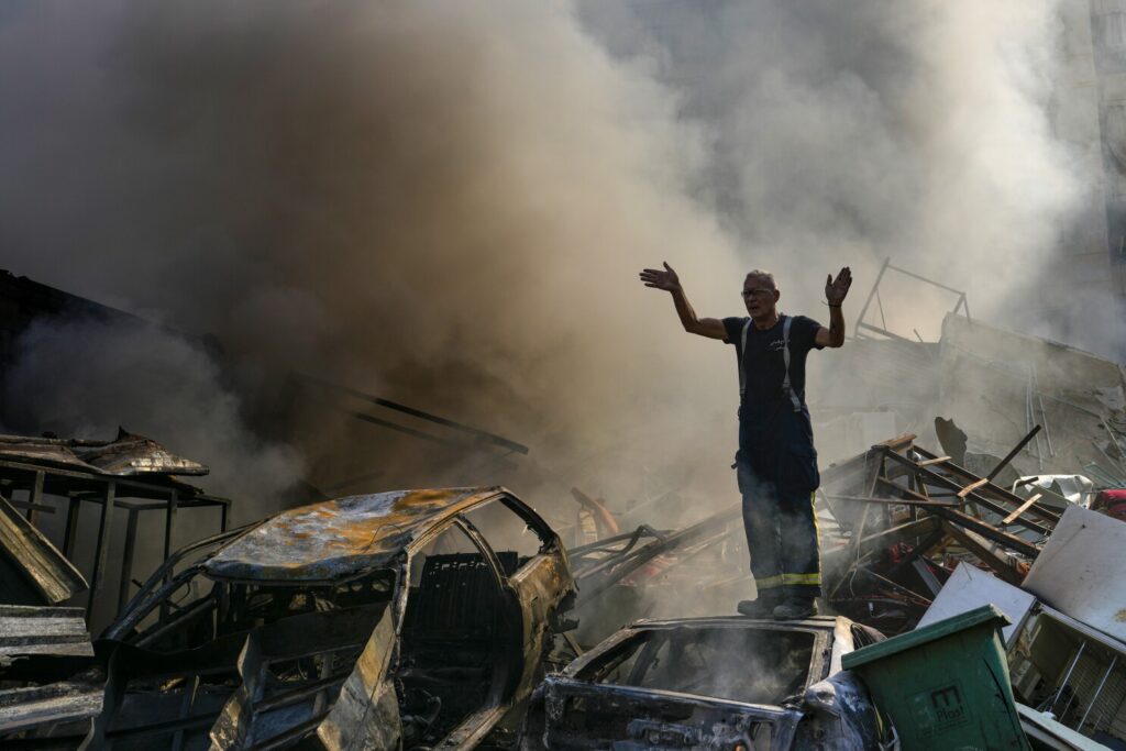 Un lucrător al apărării civile gesticulează în timp ce fumul se ridică de la locul unui atac aerian israelian în Dahiyeh, Beirut, Liban, vineri, 1 noiembrie 2024. (AP Photo/Hassan Ammar)