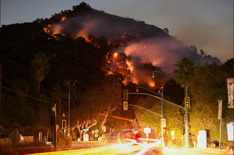 O vedere a flăcărilor de la munte văzută din Canionul Topanga lângă Pacific Palisades din Topanga, Los Angeles, California