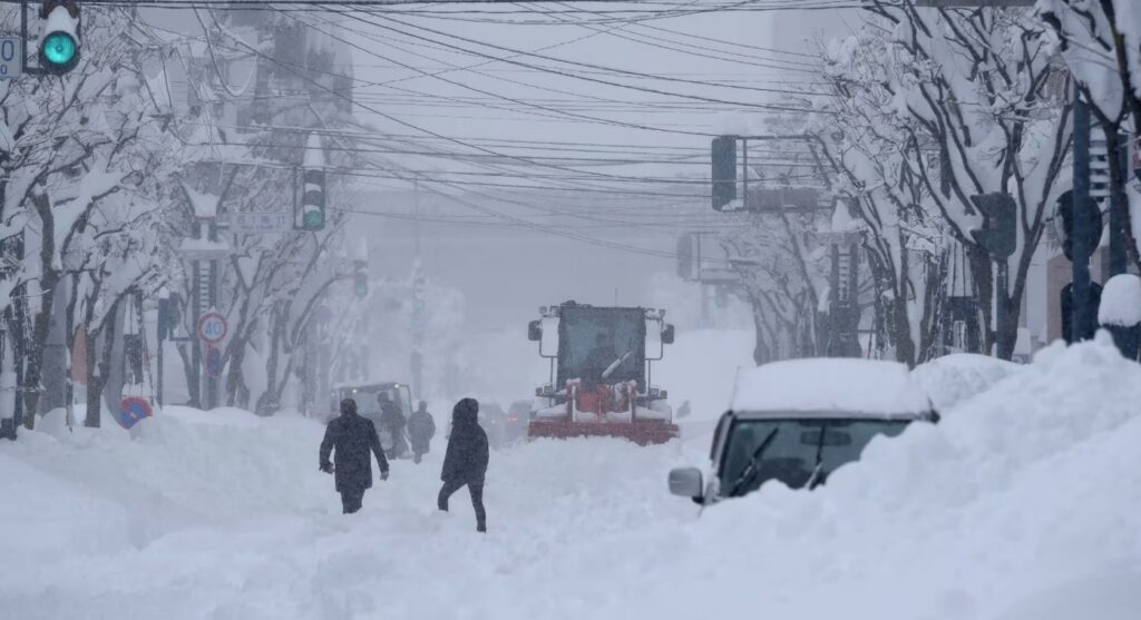 Mașini grele sunt folosite pentru a curăța un drum în timp ce zăpada cade în nordul Japoniei, în orașul Obihiro, prefectura Hokkaido