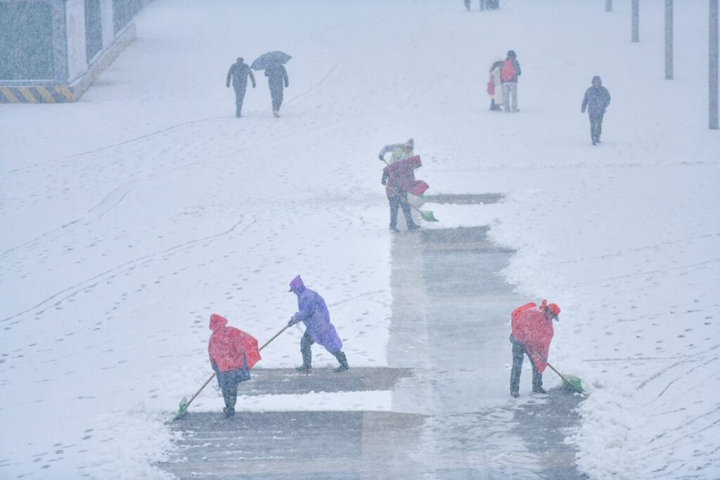 Personalul de curățenie curăță zăpada la gara Jinan West din Jinan, China, pe 2 martie